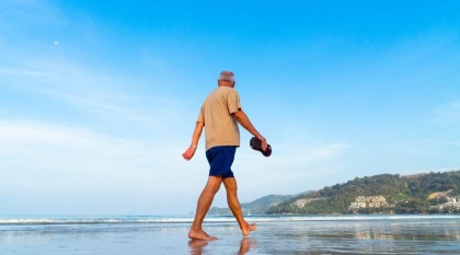 A man walking along the beach for exercise.
