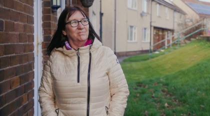 Gina, who has vascular dementia, stands outside her house.