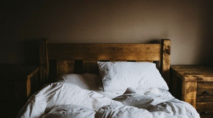 Ruffled sheets and pillows on wooden bed.